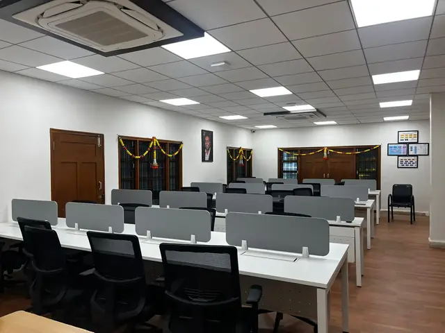 Open workstation area at Rays EdTech with rows of desks and cubicle partitions